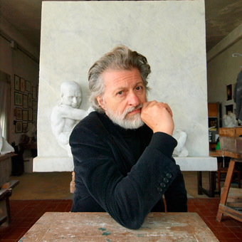 Alessandro Macchi nel suo studio, davanti a una sua scultura in marmo